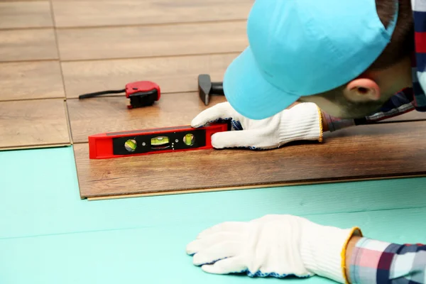 Timmerman installeert laminaat vloeren in de kamer — Stockfoto