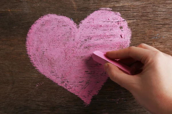 Hand draws heart on blackboard — Stock Photo, Image