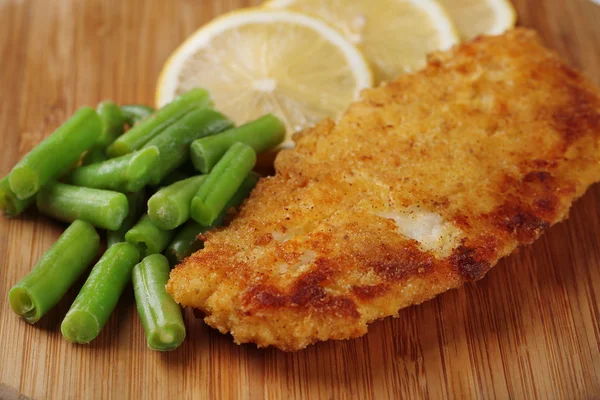 Breaded fried fillet and potatoes with asparagus and sliced lemon — Stock Photo, Image