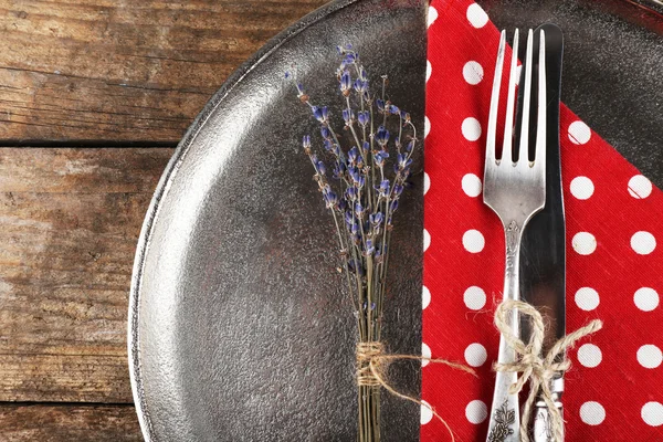 Platería atada con cuerda en bandeja de metal con servilleta colorida y flor seca sobre fondo de tablones de madera —  Fotos de Stock