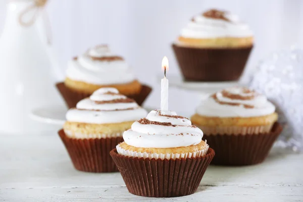 Deliciosos cupcakes de cumpleaños en la mesa sobre fondo claro —  Fotos de Stock