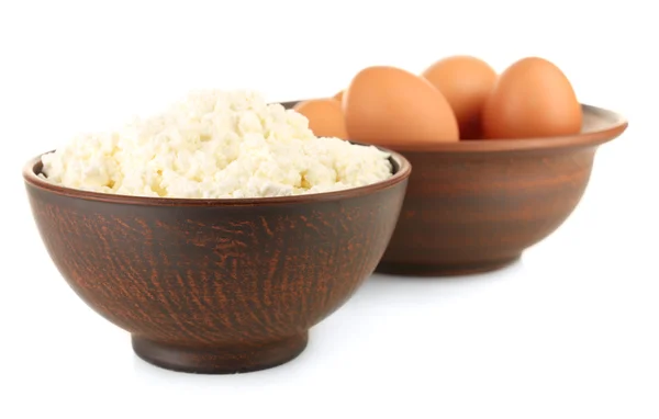 Cottage cheese and eggs in clay bowls isolated on white — Stock Photo, Image