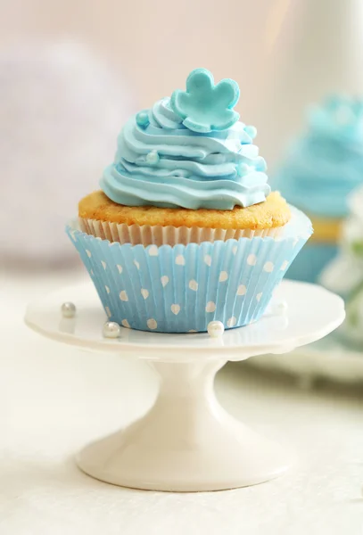 Deliciosos cupcakes en la mesa sobre fondo claro — Foto de Stock