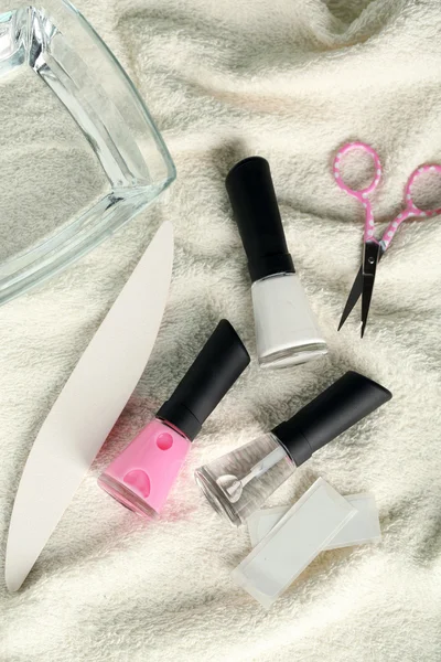 Conjunto de manicura francesa con refuerzo, esmalte de punta blanca, divisores y aplicador de brillo de capa superior para uñas sobre fondo de toalla — Foto de Stock