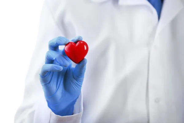 Doctor with stethoscope and small heart in hand on white background — Stock Photo, Image