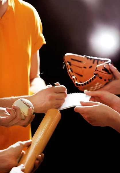 Autographs by baseball star on black and lights background