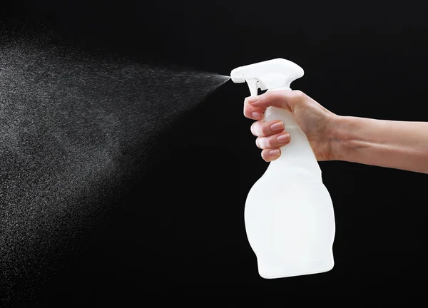 Male hand spraying water on black background — Stock Photo, Image