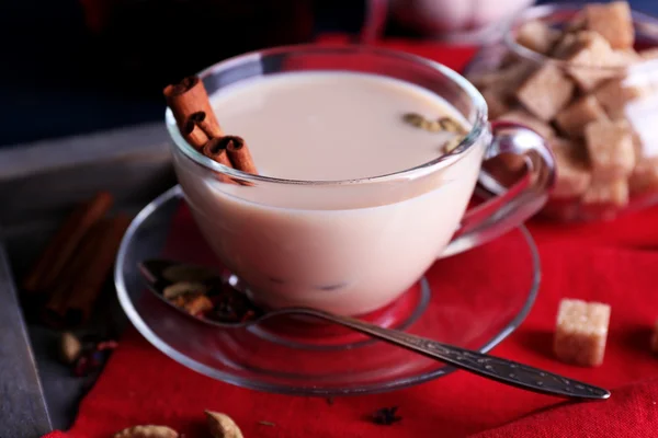 Black tea with milk and lump sugar on wooden tray with napkin and color wooden planks background — Stock Photo, Image