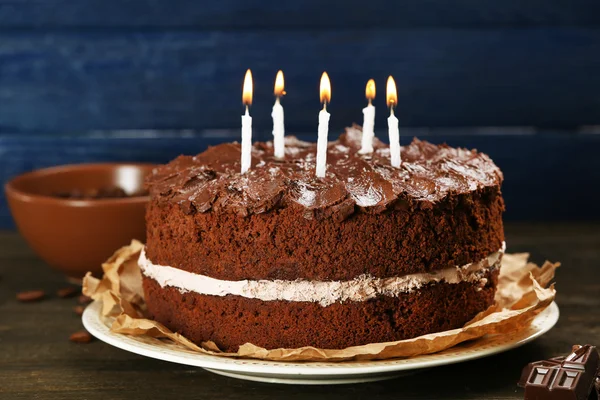 Delicioso pastel de chocolate en la mesa sobre fondo azul —  Fotos de Stock