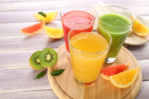 Jugos frescos con frutas en mesa de madera — Foto de Stock