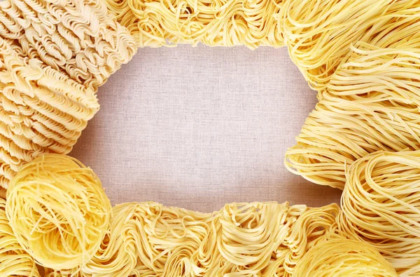 Diverse tagliatelle istantanee asciutte su sfondo di lino — Foto Stock