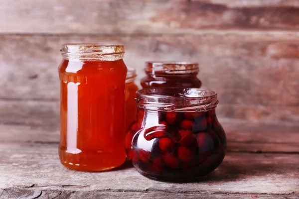 Domácí sklenice ovoce jam na rustikální dřevěné pozadí — Stock fotografie