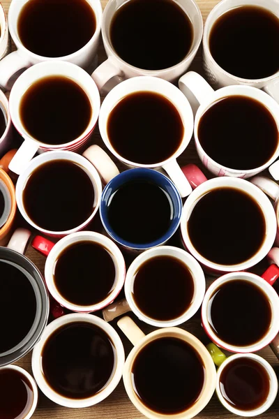 Многие чашки кофе на фоне деревянного стола, крупным планом — стоковое фото