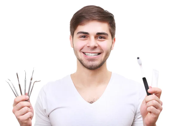 Πορτρέτο των νέων χαμογελαστός άνθρωπος με τα Οδοντιατρικά εργαλεία αποστειρώνονται απομονωθεί σε λευκό — Φωτογραφία Αρχείου