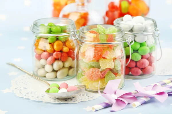 Multicolor candies in glass jars on colorful background — Stock Photo, Image