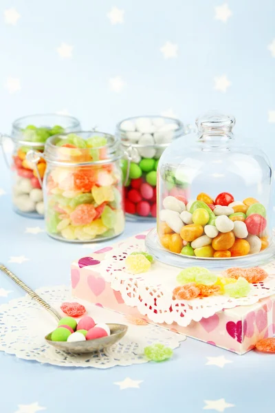 Caramelos multicolores en frascos de vidrio sobre fondo colorido —  Fotos de Stock