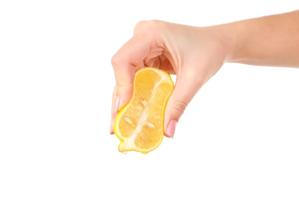 Женская рука сжимает лимон изолированный на белом — стоковое фото