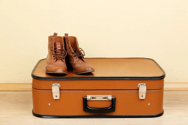 Maleta vintage con zapatos masculinos en suelo de madera y fondo de pantalla claro —  Fotos de Stock