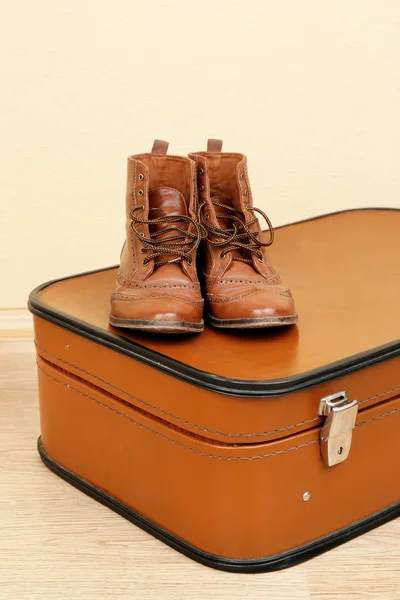 Maleta vintage con zapatos masculinos en suelo de madera y fondo de pantalla claro —  Fotos de Stock