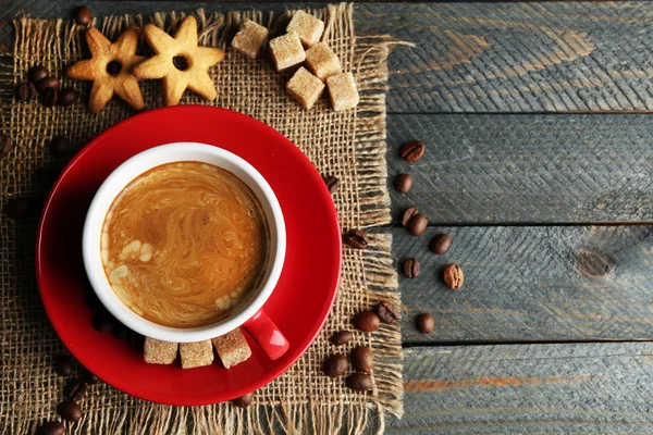 Kopp kaffe och välsmakande kakor på säckväv Servett, på trä bakgrund — Stockfoto