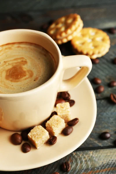 Tasse Kaffee und leckere Plätzchen auf Holzuntergrund — Stockfoto