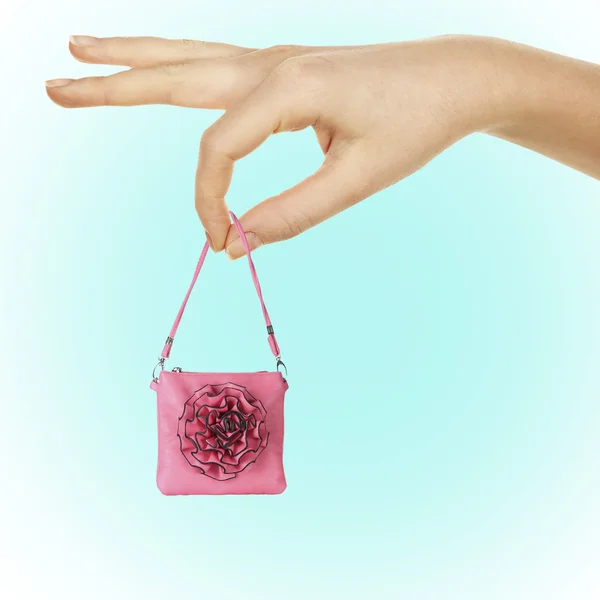 水色の背景の大きな手で小さな女性ハンドバッグ — ストック写真