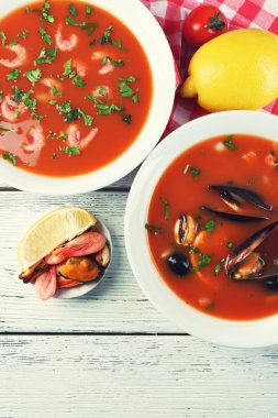 Lezzetli çorba, karides, midye, domates ve kase ahşap arka plan üzerinde Siyah Zeytin