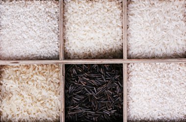 Pirinç kutusunda ahşap arka plan üzerinde farklı türleri