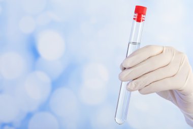 Tüp parlak arka planda tutan el