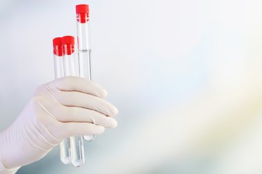 Test tüpleri açık renkli üzerinde tutan el