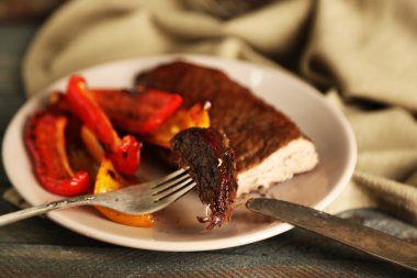 Lezzetli kızarmış et ve sebze ahşap arka plan üzerinde plaka ile kompozisyon