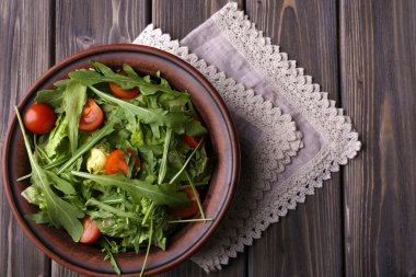 Roka ve ahşap masa üzerinde domates salatası