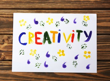 Kağıt ahşap arka plan üzerinde yazılı Word yaratıcılık