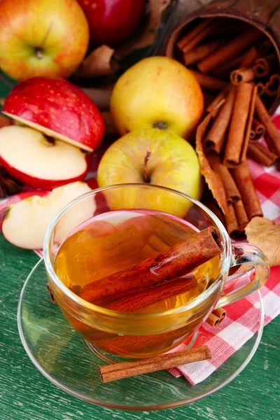 Samenstelling van appel cider met kaneelstokjes, verse appelen en Herfstbladeren op houten achtergrond — Stockfoto