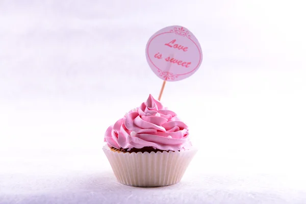 Delizioso cupcake con iscrizione sul tavolo su sfondo beige — Foto Stock