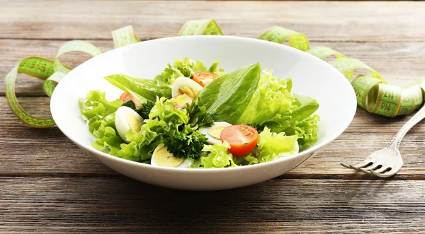 Salade met kwartel ei en basilicum in plaat op rustieke houten tafel achtergrond — Stockfoto