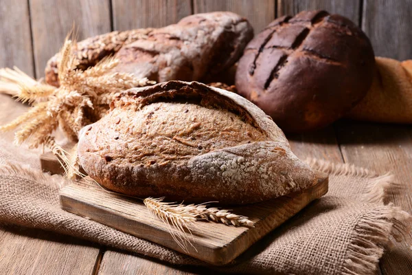 Gustoso pane sul tavolo su sfondo di legno — Foto Stock