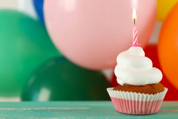 Delicioso cupcake de cumpleaños en la mesa sobre fondo brillante —  Fotos de Stock