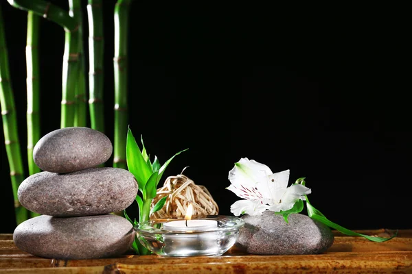 Schöne Komposition mit Wellness-Steinen und Kerze auf Tisch auf dunklem Hintergrund — Stockfoto