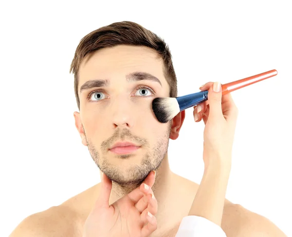 Weibliche Hand beim Make-up junger Mann isoliert auf weiß — Stockfoto