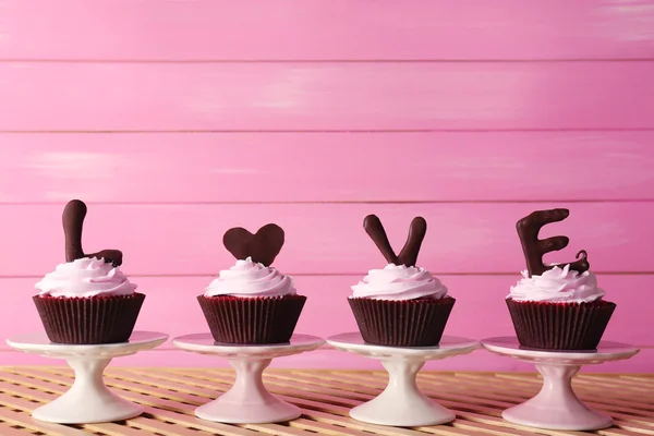 Deliciosos cupcakes de San Valentín sobre fondo de madera rosa — Foto de Stock