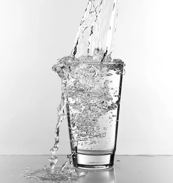 Voda proudí v izolovaných na bílém skle — Stock fotografie