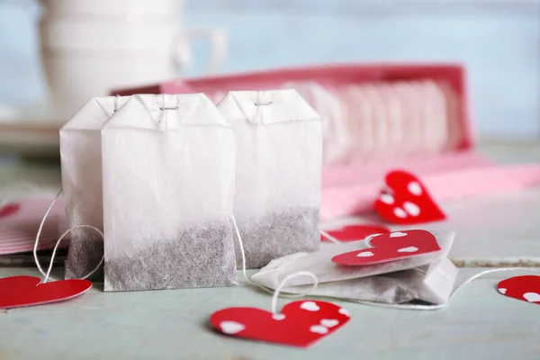 Heart shaped teabag tags and box on wooden background — Stock Photo, Image