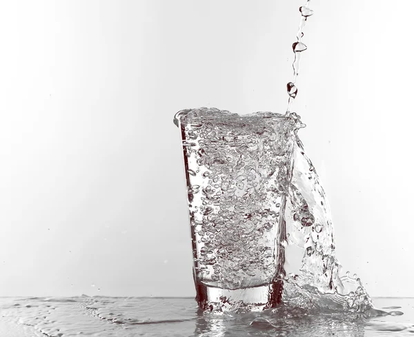 Water pouring in glass isolated on white