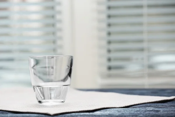 明るい背景上のテーブルの上に水のガラス — ストック写真