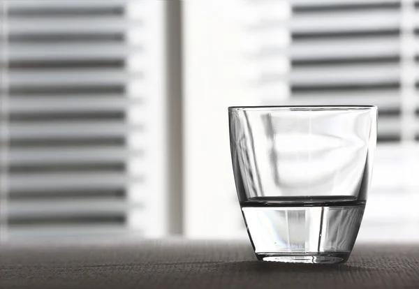 Стакан воды на столе на светлом фоне — стоковое фото