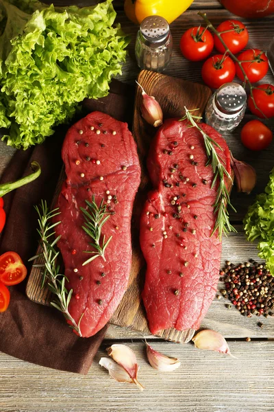 Steak de bœuf cru avec épices et légumes verts sur la table close up — Photo
