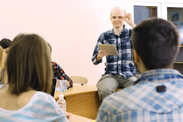 Groupe d'étudiants assis en classe et enseignant à l'écoute — Photo