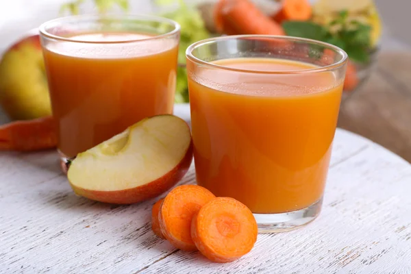 Los vasos del jugo con la manzana y la zanahoria sobre la mesa de madera se acercan — Foto de Stock