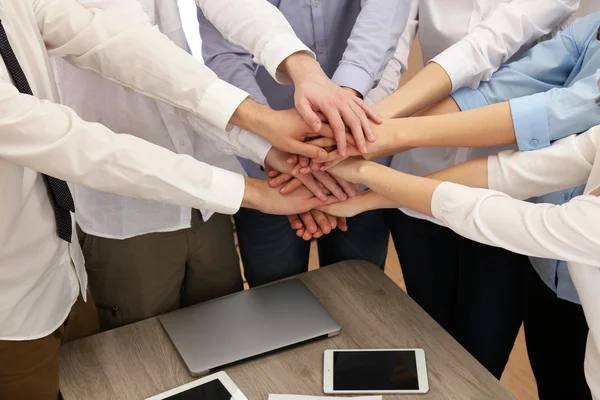 Mãos unidas da equipe de negócios no fundo do espaço de trabalho — Fotografia de Stock